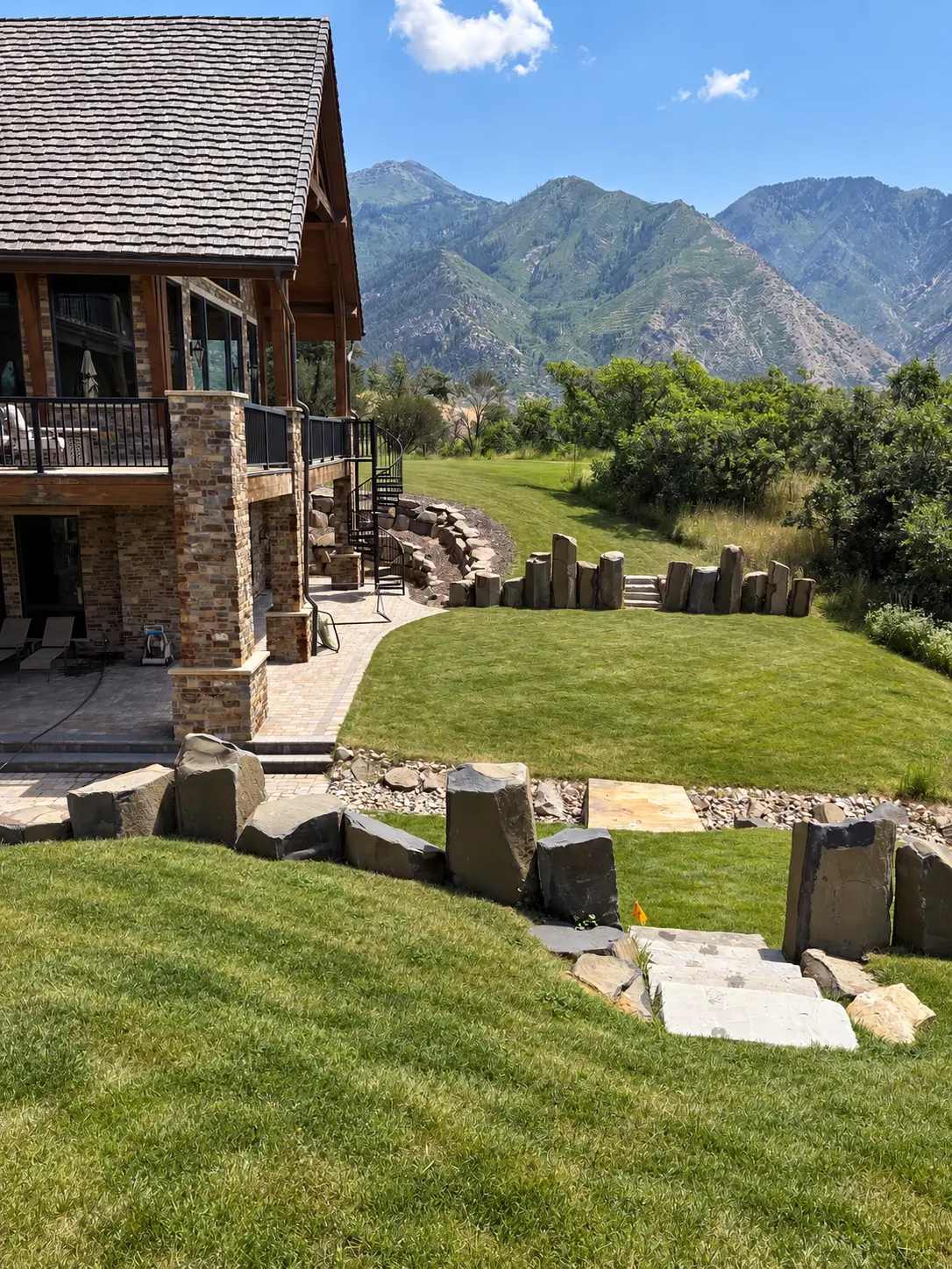 Utah mountain property with landscaped lawn, stone retaining features and flagstone walkway
